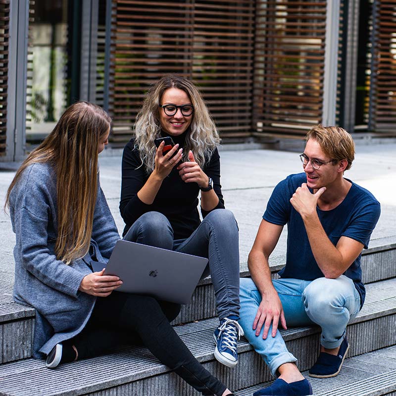 students-looking-at-computer-together-outside