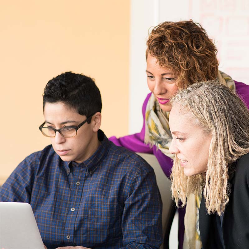 three people looking at a computer screen in a clinic together